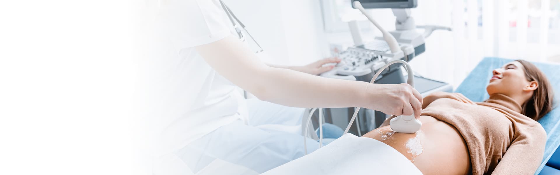 Eine entspannte schwangere Frau liegt auf einer Untersuchungsliege während einer Ultraschalluntersuchung, durchgeführt von einer medizinischen Fachkraft in weißer Berufskleidung, in einem hellen und modernen Diagnoseraum.