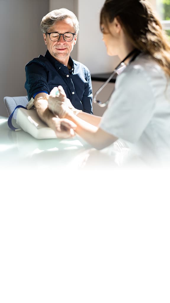 Ärztin nimmt einem Patienten Blut ab